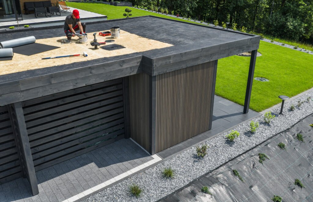 Travailleurs effectuant l'entretien de la toiture d'un bâtiment moderne entouré de verdure